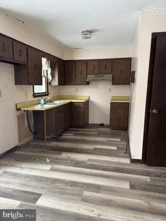 a view of kitchen with sink and refrigerator