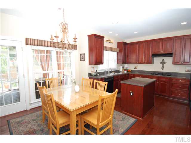 6101 Tiffield Way Wake Forest, NC 27587 - Photo 11 of 25 a kitchen with a stove a sink a dining table and chairs