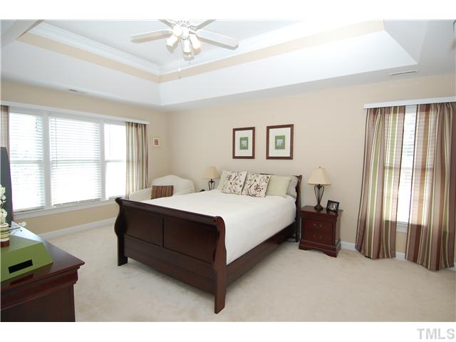 6101 Tiffield Way Wake Forest, NC 27587 - Photo 13 of 25 a spacious bedroom with a bed and a chandelier