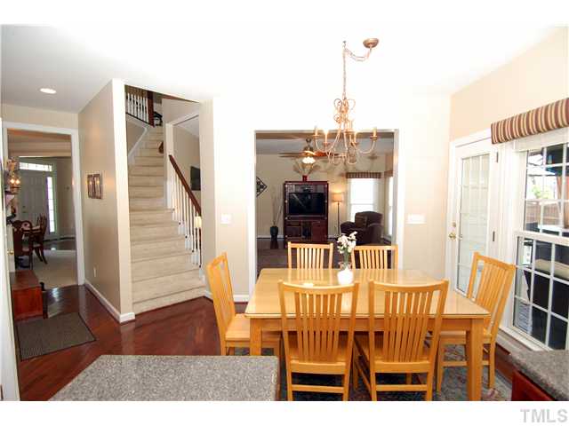 6101 Tiffield Way Wake Forest, NC 27587 - Photo 10 of 25 a dining room with furniture wooden floor and a chandelier