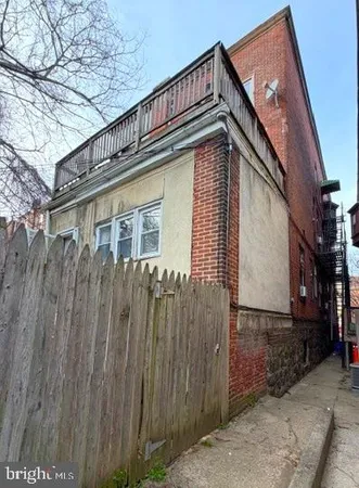 a view of a house with a wooden fence