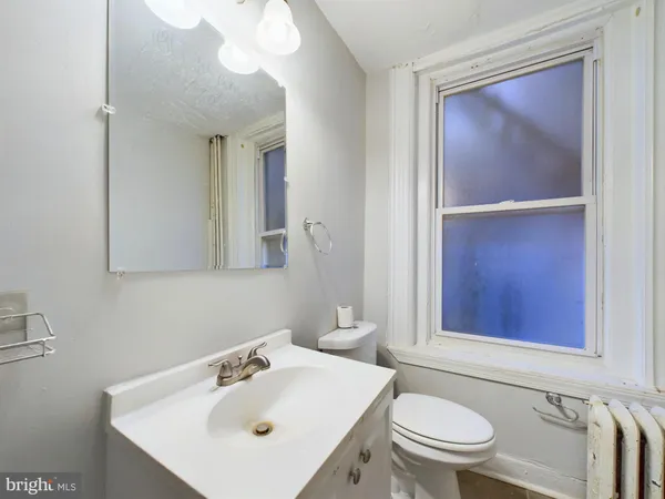 a bathroom with a sink mirror and toilet
