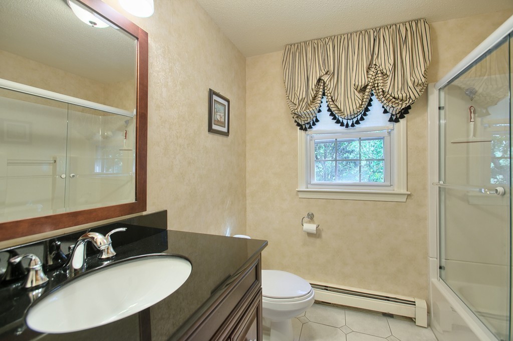 25 Autumn Road Lunenburg, MA 01462 - Photo 17 of 26 a bathroom with a granite countertop sink mirror vanity and toilet