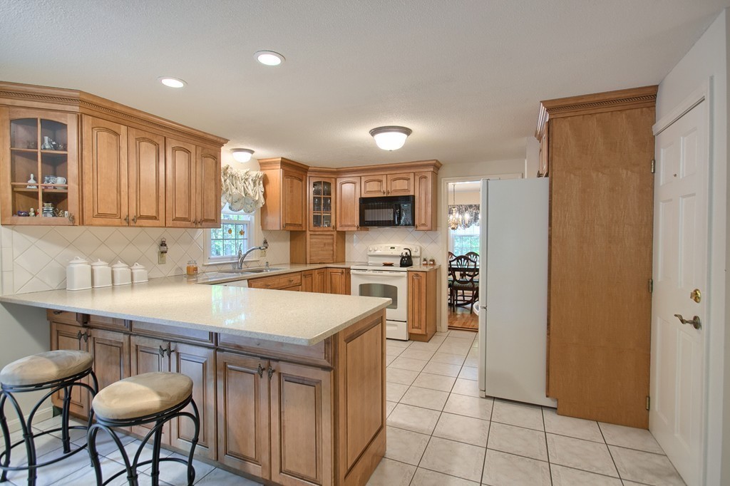 25 Autumn Road Lunenburg, MA 01462 - Photo 5 of 26 a kitchen with stainless steel appliances granite countertop a table chairs sink refrigerator and cabinets