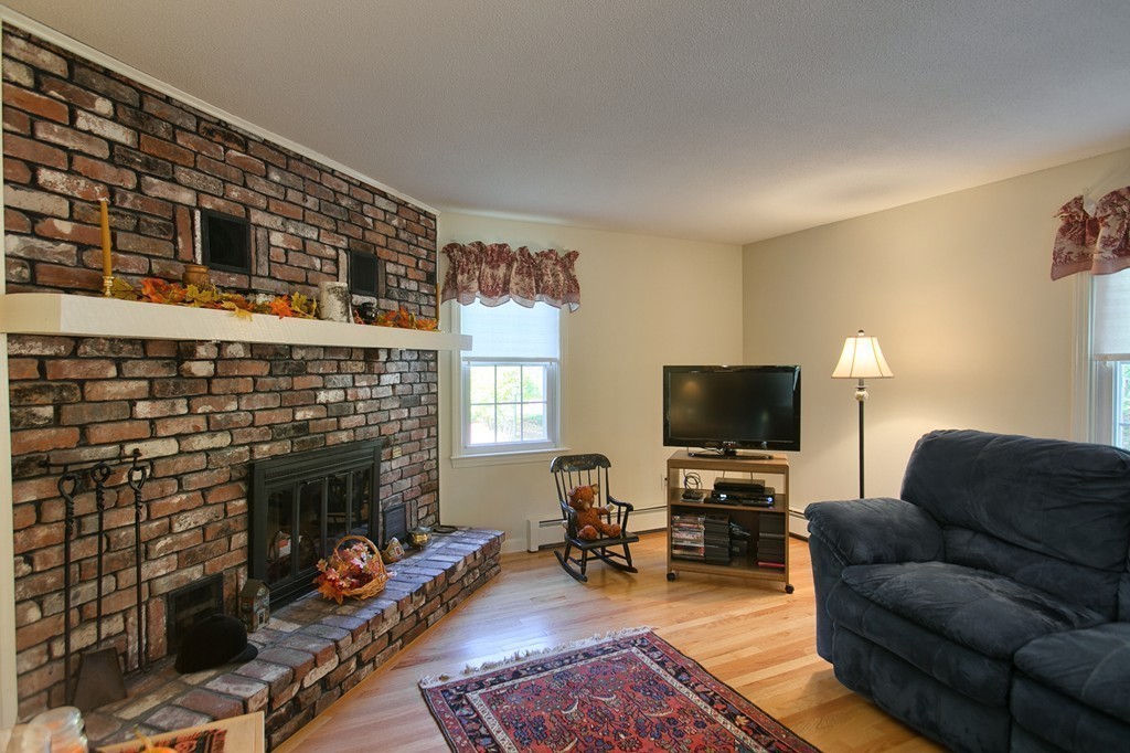 25 Autumn Road Lunenburg, MA 01462 - Photo 8 of 26 a living room with furniture a fireplace and a flat screen tv