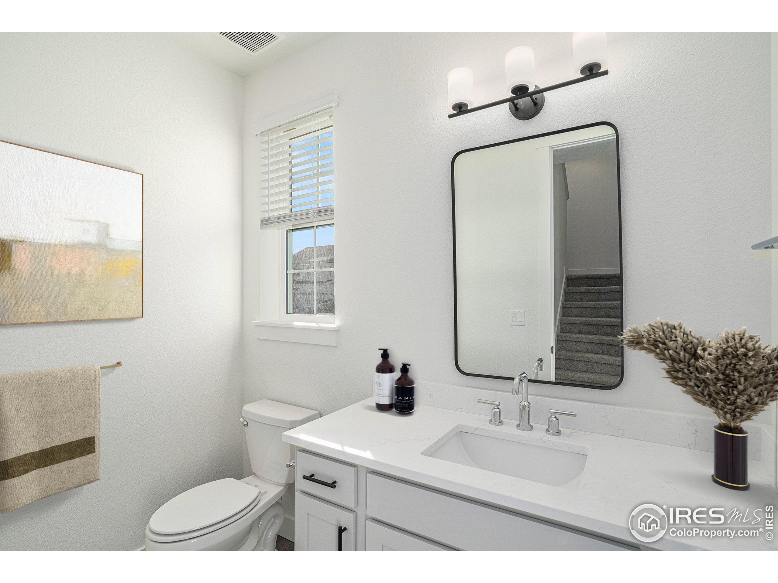 5049 Avon Avenue Loveland, CO 80538 - Photo 5 of 10 a bathroom with a toilet sink and mirror