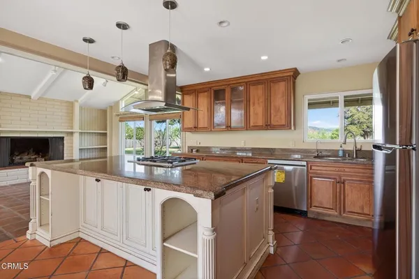 a kitchen with stainless steel appliances granite countertop a stove a sink and a refrigerator