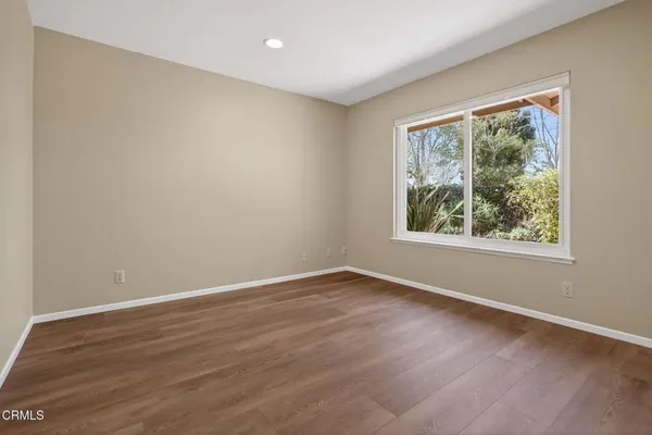 a view of empty room with wooden floor and fireplace
