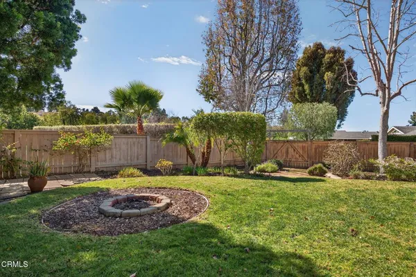 a front view of a house with a garden and trees