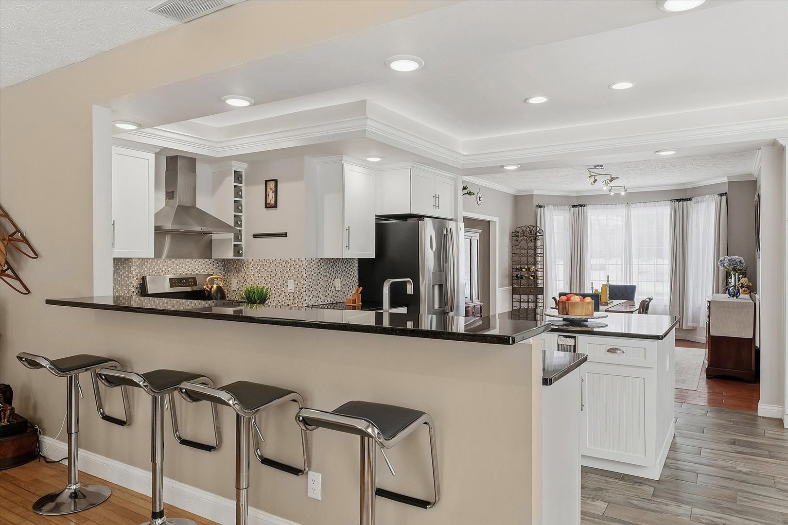1307 Cross Creek Road Mahomet, IL 61853 - Photo 17 of 75 a kitchen with stainless steel appliances granite countertop a refrigerator a sink a stove and chairs with wooden floor
