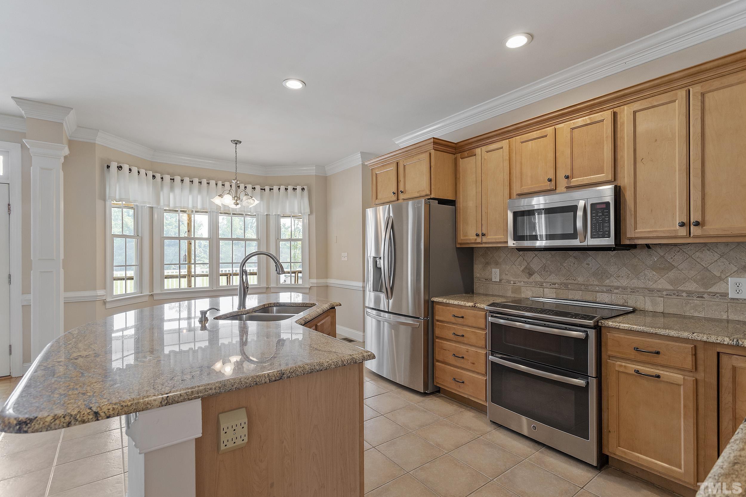 90 Fletcher Ridge Road Timberlake, NC 27583 - Photo 10 of 26 a kitchen with stainless steel appliances granite countertop a stove top oven a refrigerator and white cabinets with wooden floor