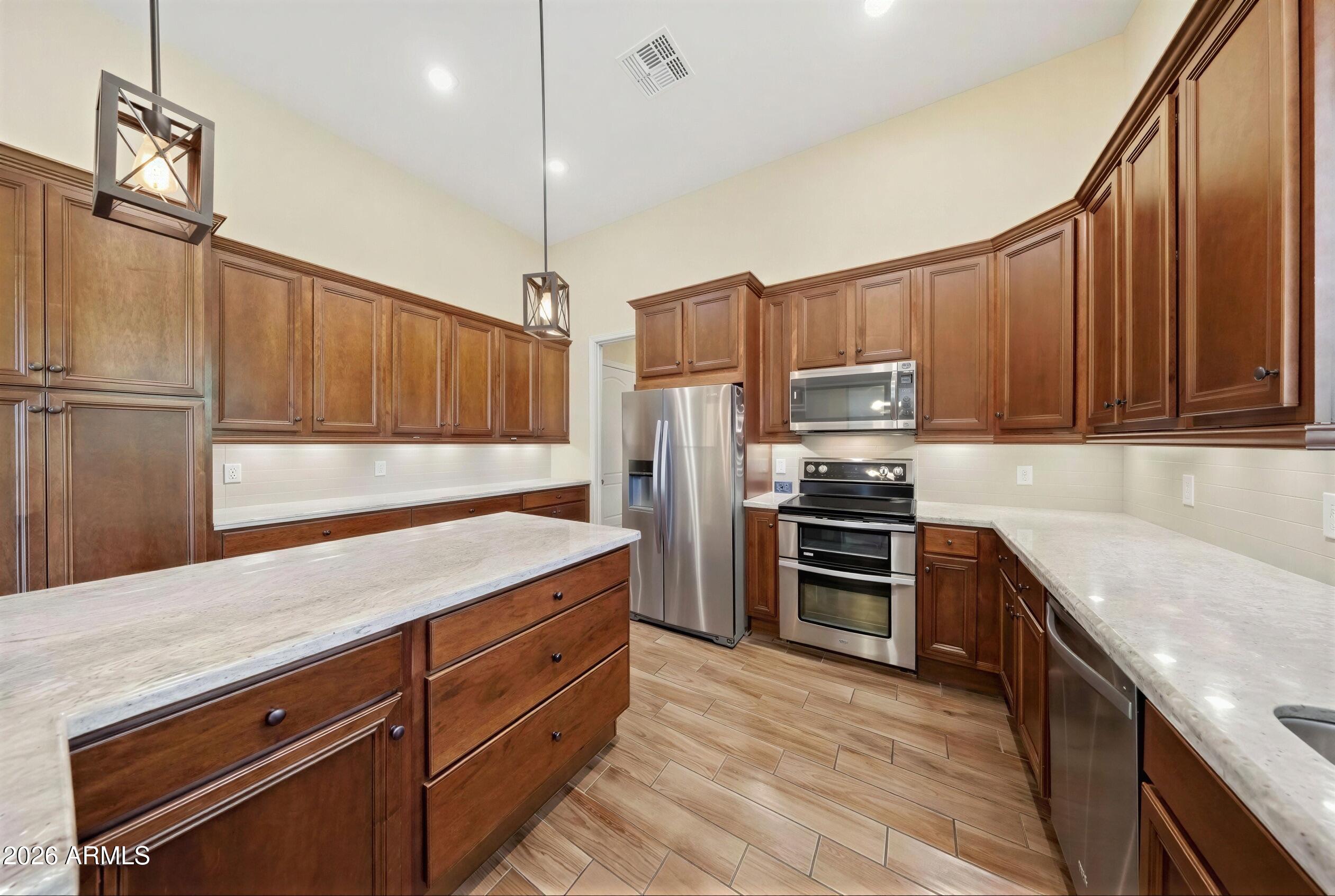 8974 North 8th Lane Phoenix, AZ 85021 - Photo 11 of 29 a kitchen with kitchen island granite countertop a sink appliances and cabinets