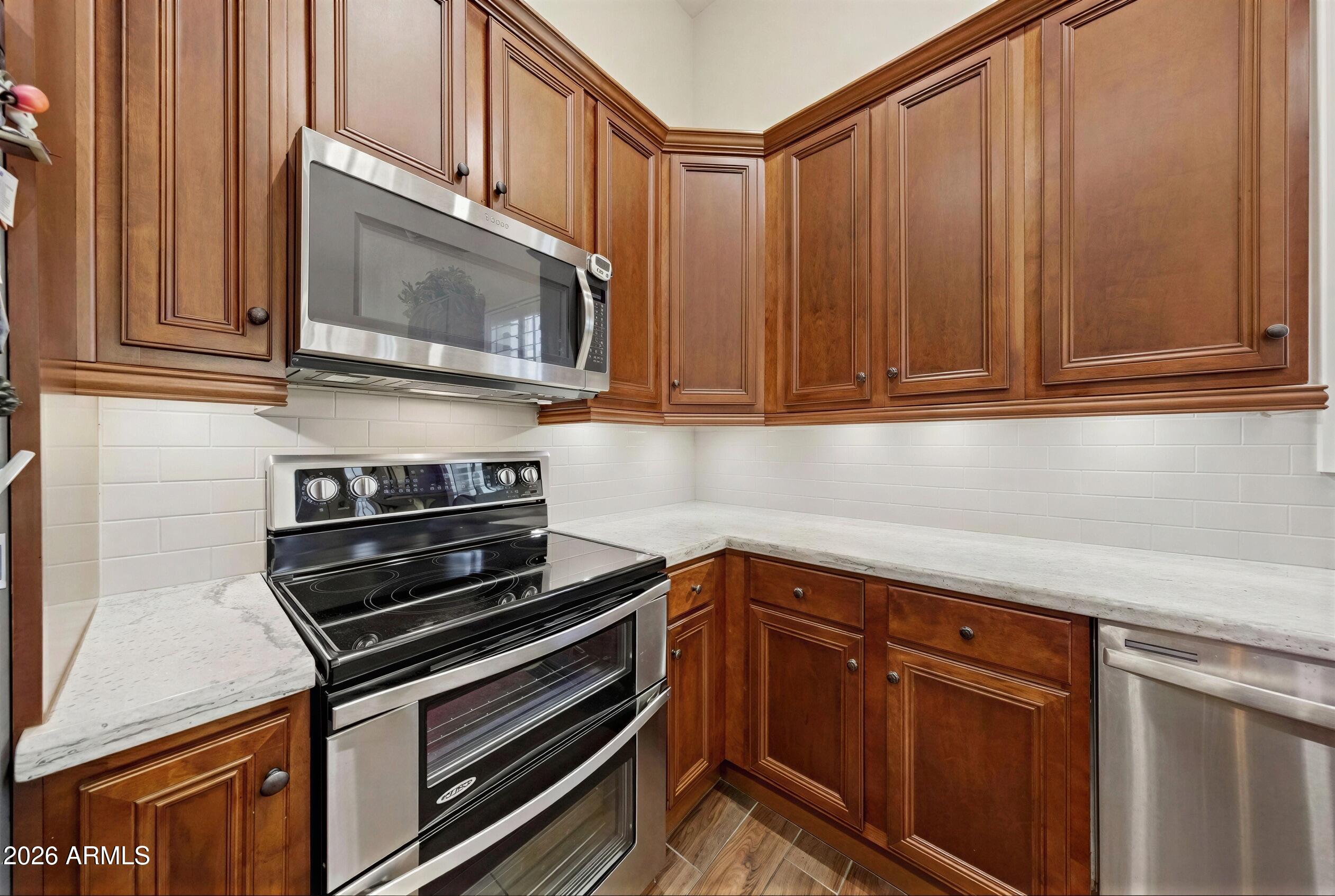 8974 North 8th Lane Phoenix, AZ 85021 - Photo 12 of 29 a kitchen with wooden cabinets and a stove top oven