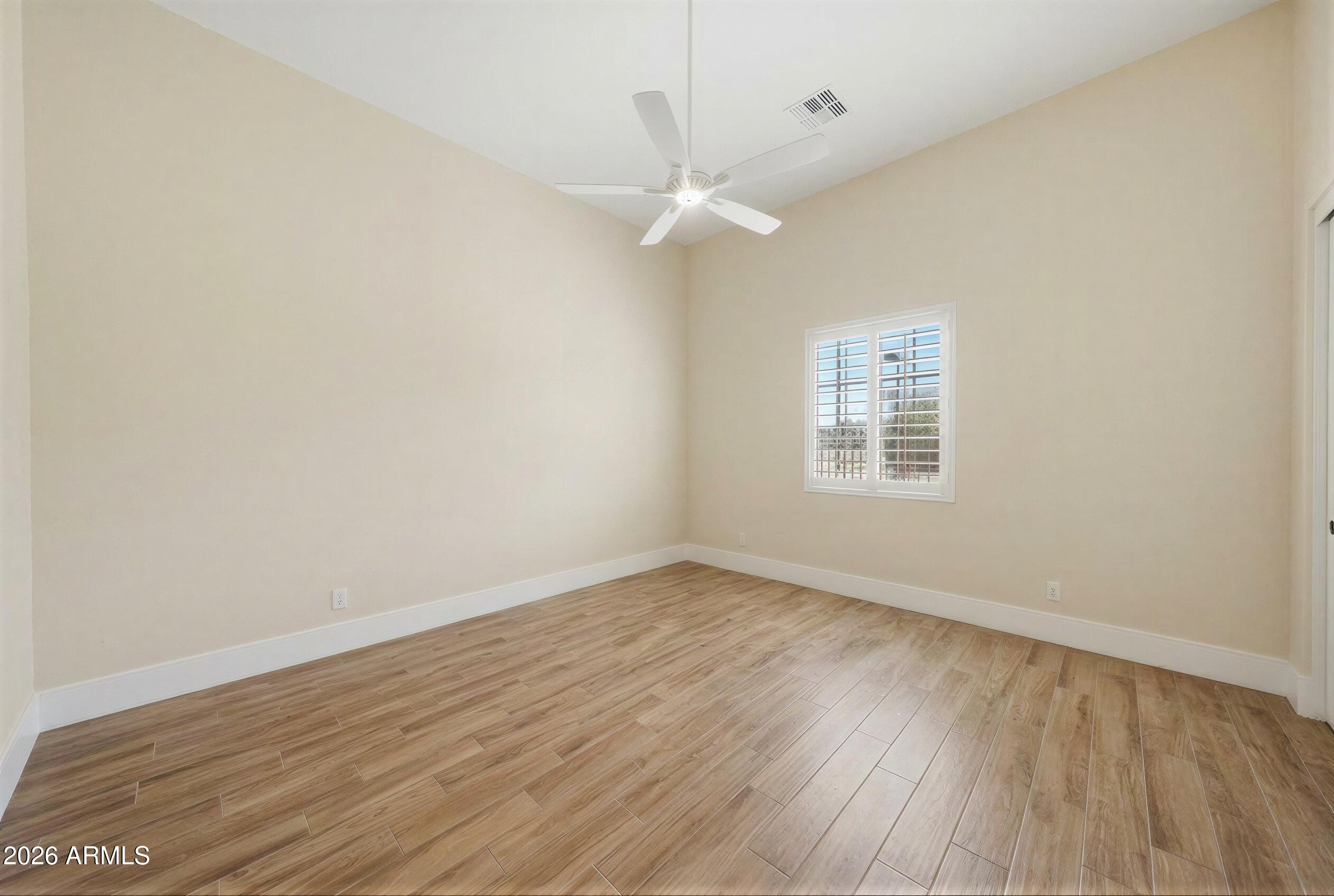 8974 North 8th Lane Phoenix, AZ 85021 - Photo 17 of 29 an empty room with wooden floor fan and windows
