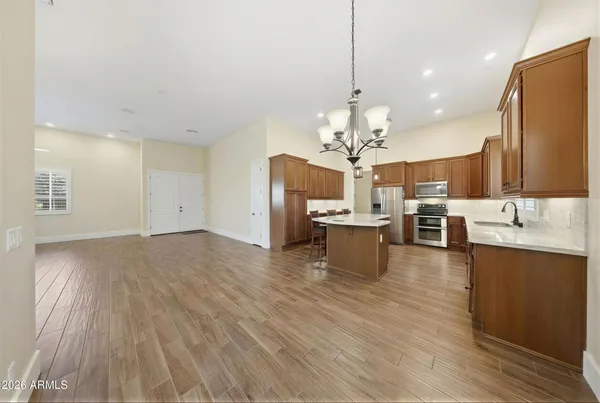 a kitchen with granite countertop cabinets stainless steel appliances wooden floor and a window