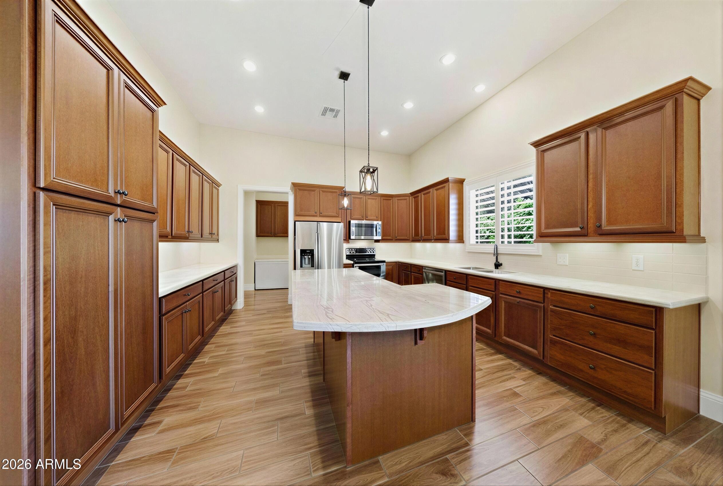 8974 North 8th Lane Phoenix, AZ 85021 - Photo 8 of 29 a large kitchen with stainless steel appliances granite countertop a sink a counter space and wooden floor