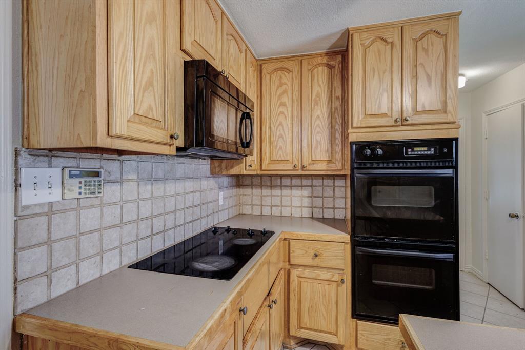 7305 Ridgeview Drive Rowlett, TX 75089 - Photo 22 of 32 a kitchen with granite countertop a stove a sink and a microwave