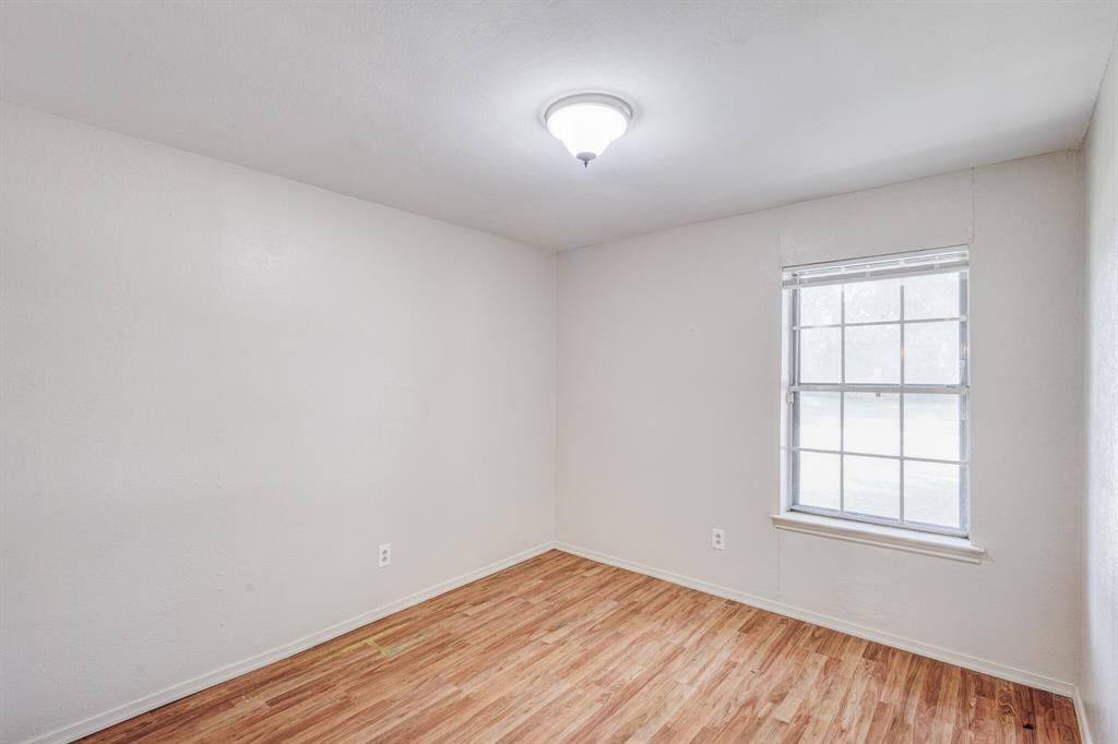 7305 Ridgeview Drive Rowlett, TX 75089 - Photo 4 of 32 an empty room with wooden floor and windows