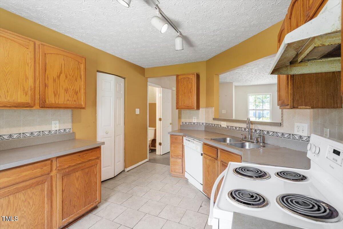 4221 Tensity Drive Raleigh, NC 27604 - Photo 10 of 31 a kitchen with a sink a stove and cabinets