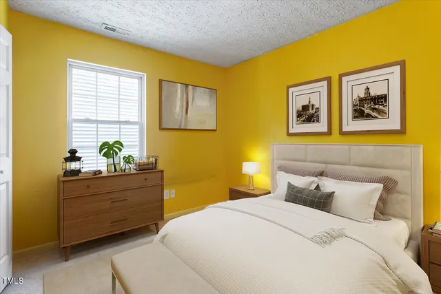 a bedroom with a bed and paintings on the wall