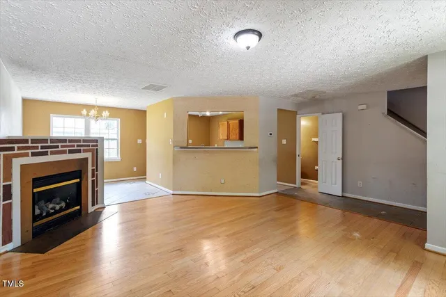 a view of an empty room with a fireplace and a window