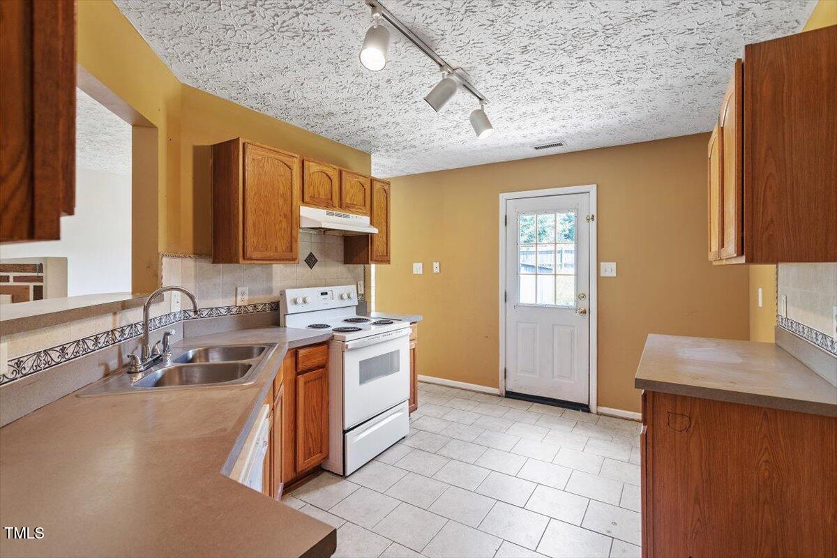 4221 Tensity Drive Raleigh, NC 27604 - Photo 9 of 31 a kitchen with stainless steel appliances granite countertop a sink stove and refrigerator