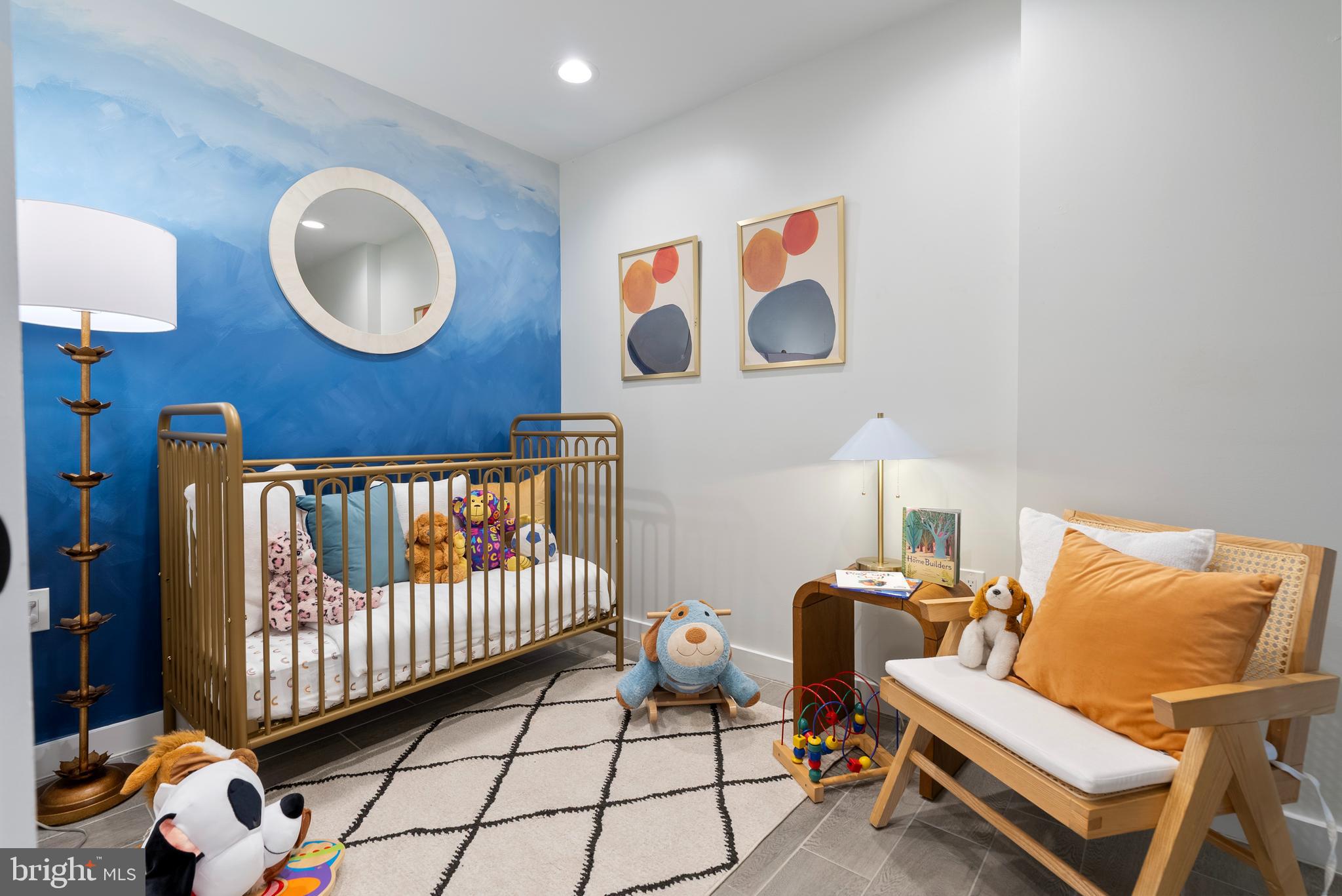 210 Varnum Street Northwest, Unit 1 Washington, DC 20011 - Photo 15 of 22 a bedroom with a baby bed a couch and a lamp on the table
