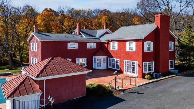 an aerial view of a house with swimming pool a yard and a mountain view