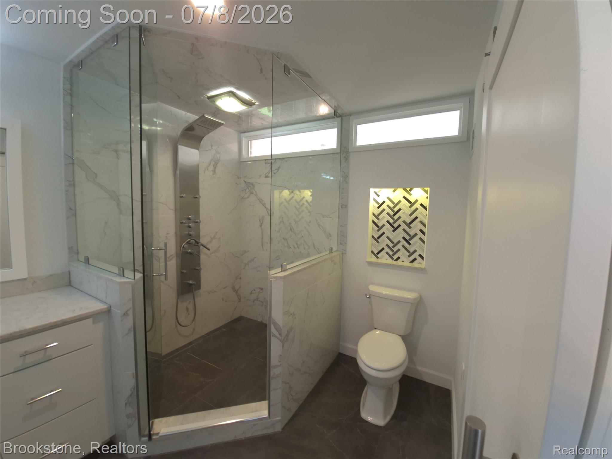 4140 South Henderson Road Davison, MI 48423 - Photo 52 of 98 Modern bathroom featuring a glass-enclosed shower with a multi-function shower panel and marble-look tile surround