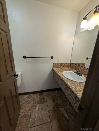 a bathroom with a granite countertop sink and a mirror