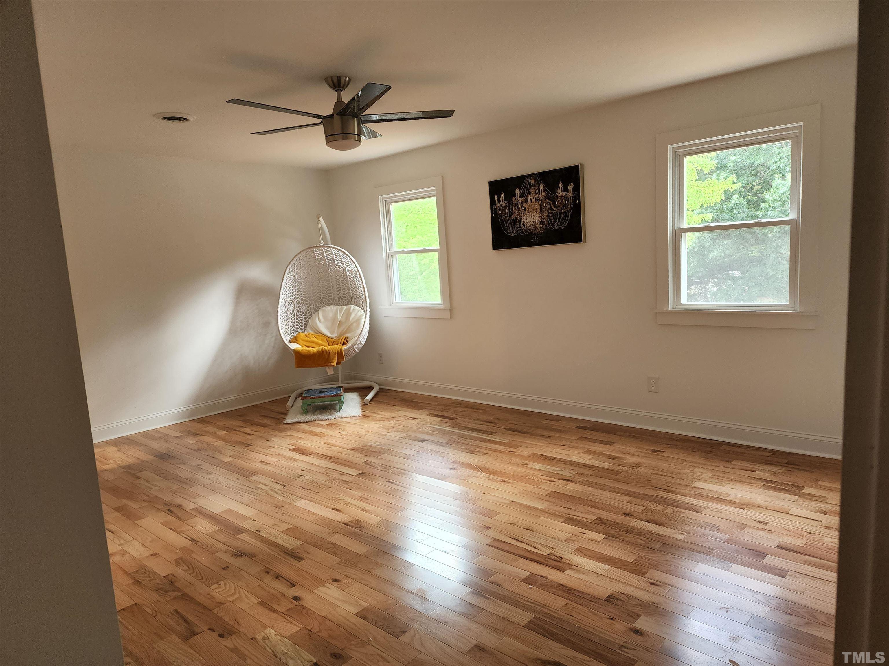 4200 Pickwick Drive Raleigh, NC 27613 - Photo 19 of 36 a room with window wooden floor and a ceiling fan