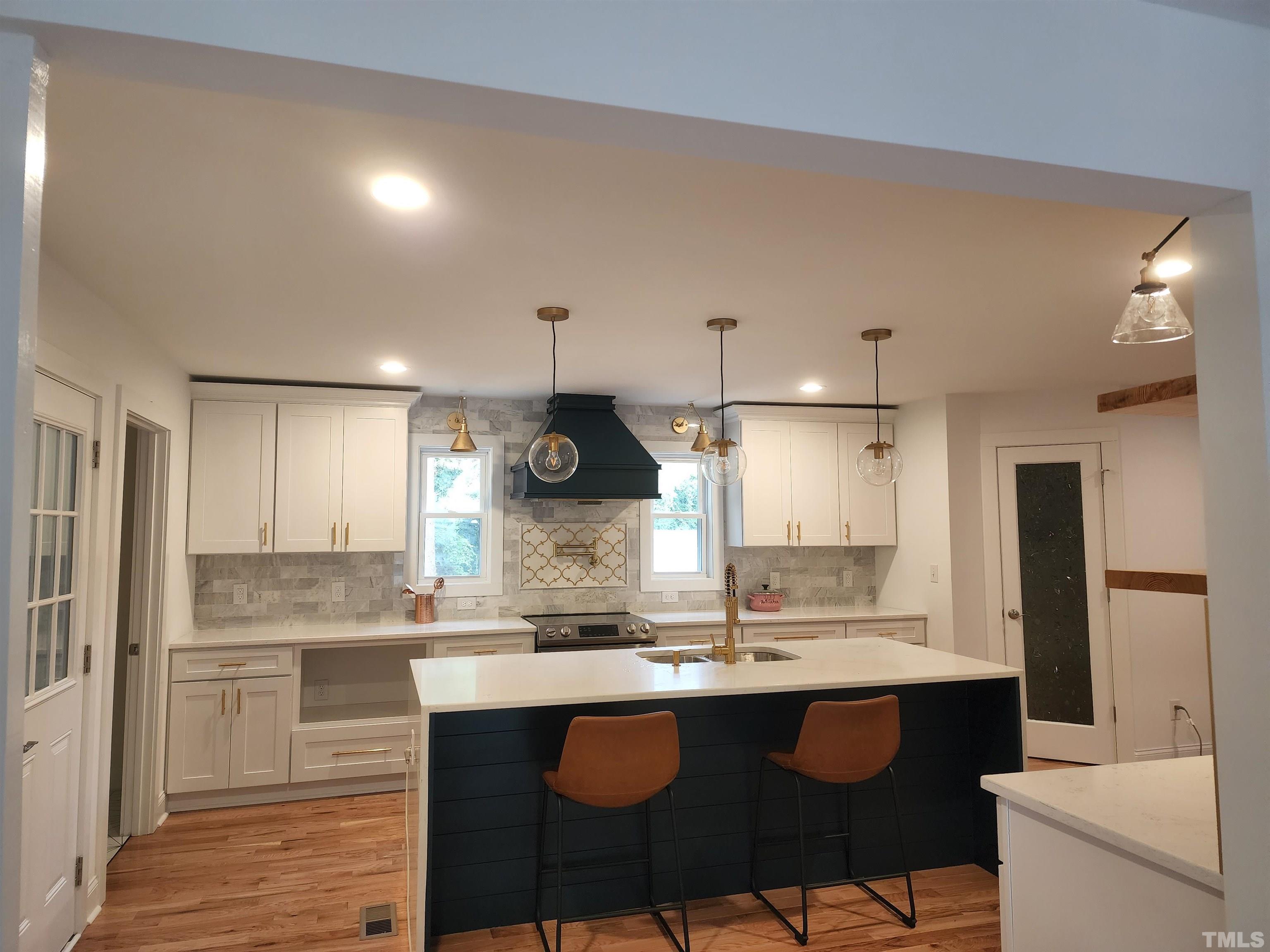 4200 Pickwick Drive Raleigh, NC 27613 - Photo 3 of 36 a kitchen with a sink and chairs