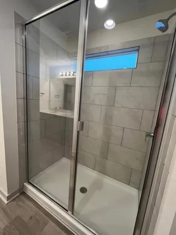 a spacious bathroom with a double vanity sink a mirror and a shower