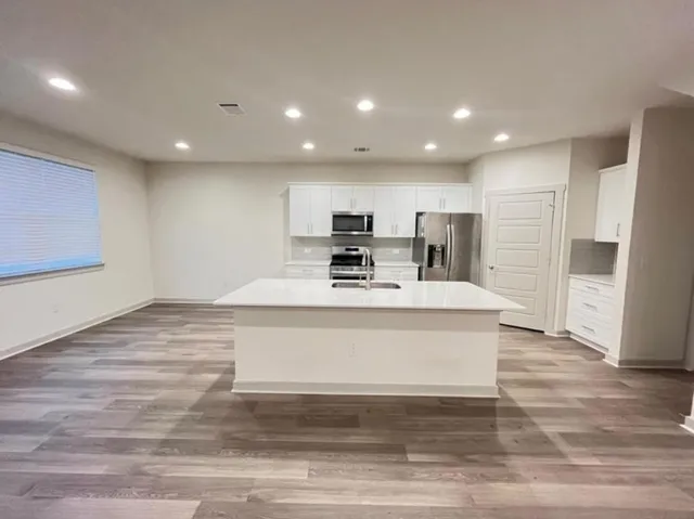 a view of kitchen with stainless steel appliances refrigerator stove microwave and cabinets