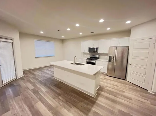 a large white kitchen with a sink a refrigerator and a stove