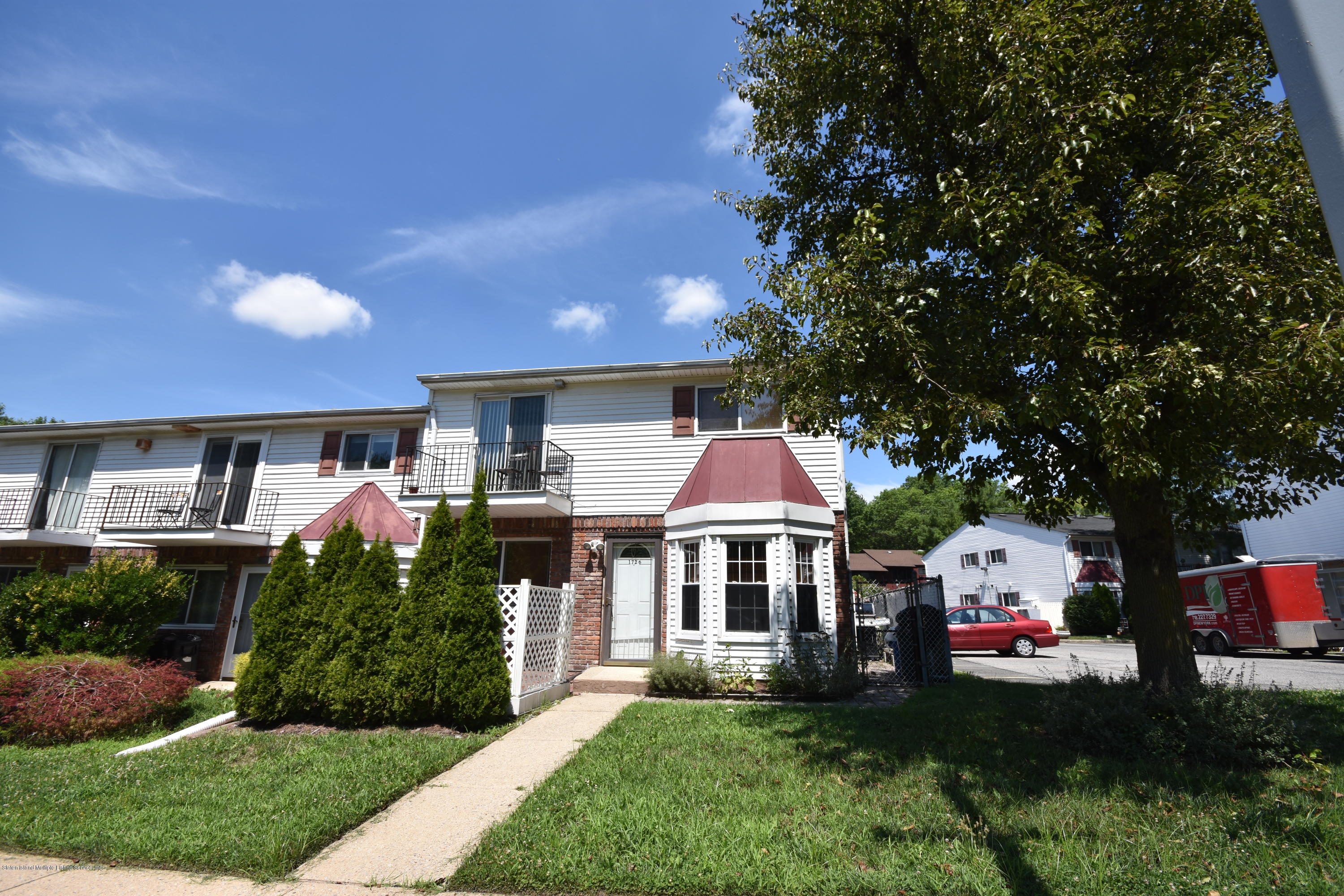 1726 Forest Hill Road Staten Island, NY 10314 - Photo 12 of 12 a front view of a house with a yard and garage
