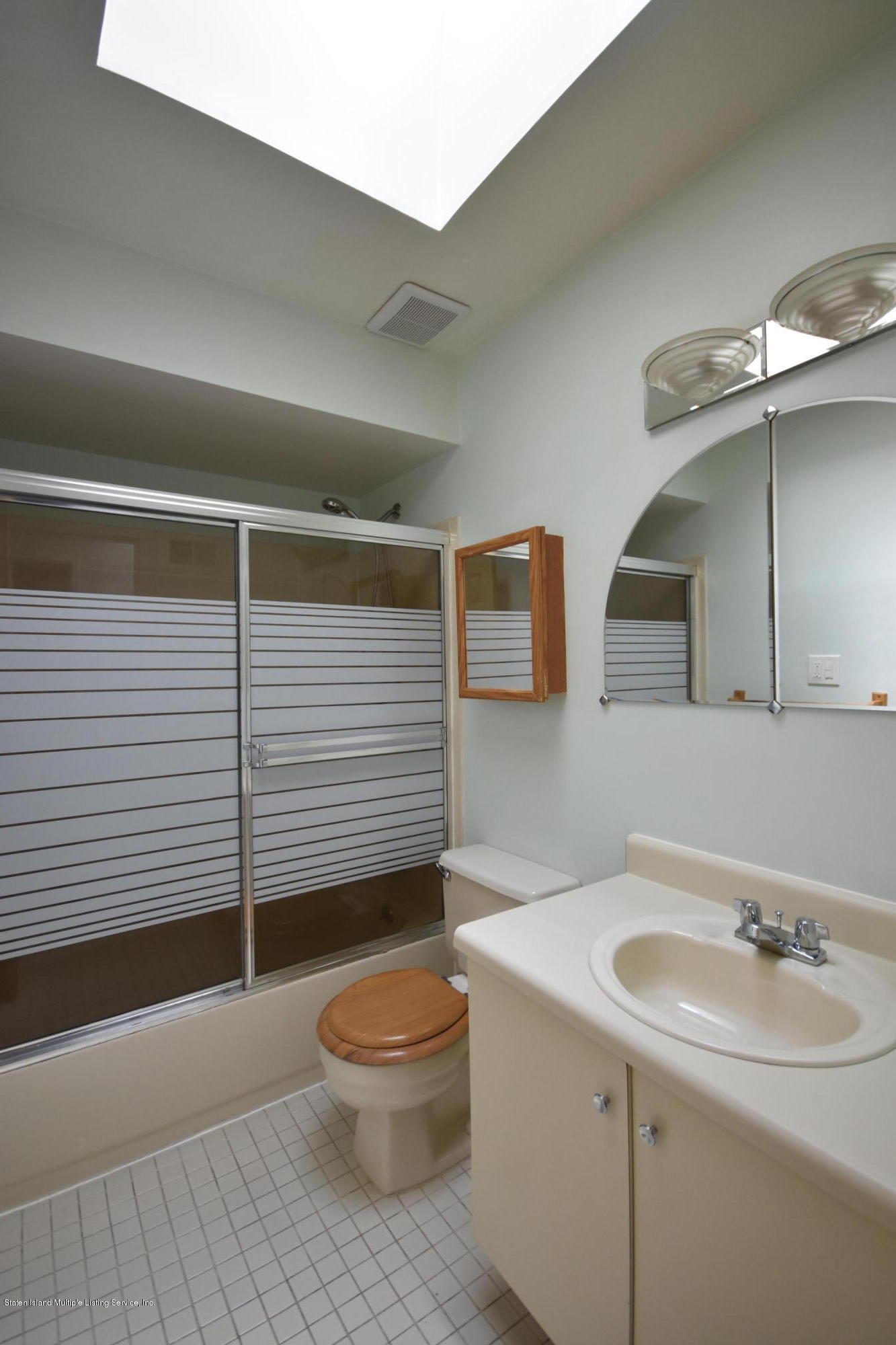 1726 Forest Hill Road Staten Island, NY 10314 - Photo 6 of 12 a bathroom with a sink a toilet and mirror