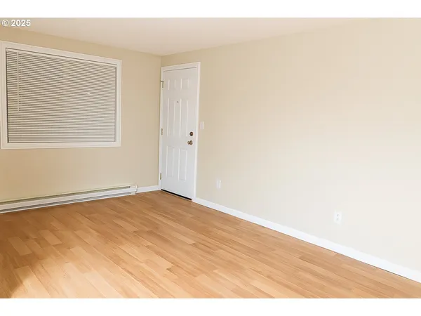 a view of an empty room with wooden floor