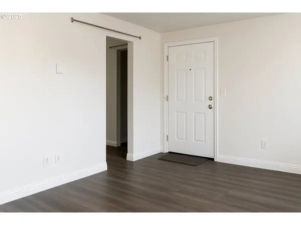 a view of an empty room with wooden floor