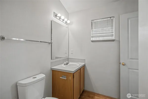 a bathroom with a toilet a sink and mirror