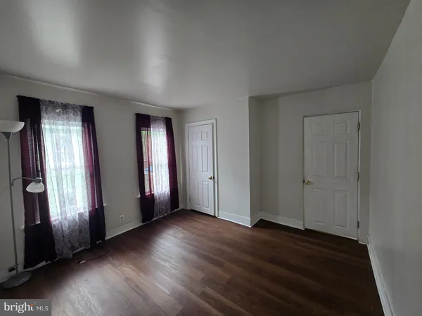 an empty room with wooden floor and window