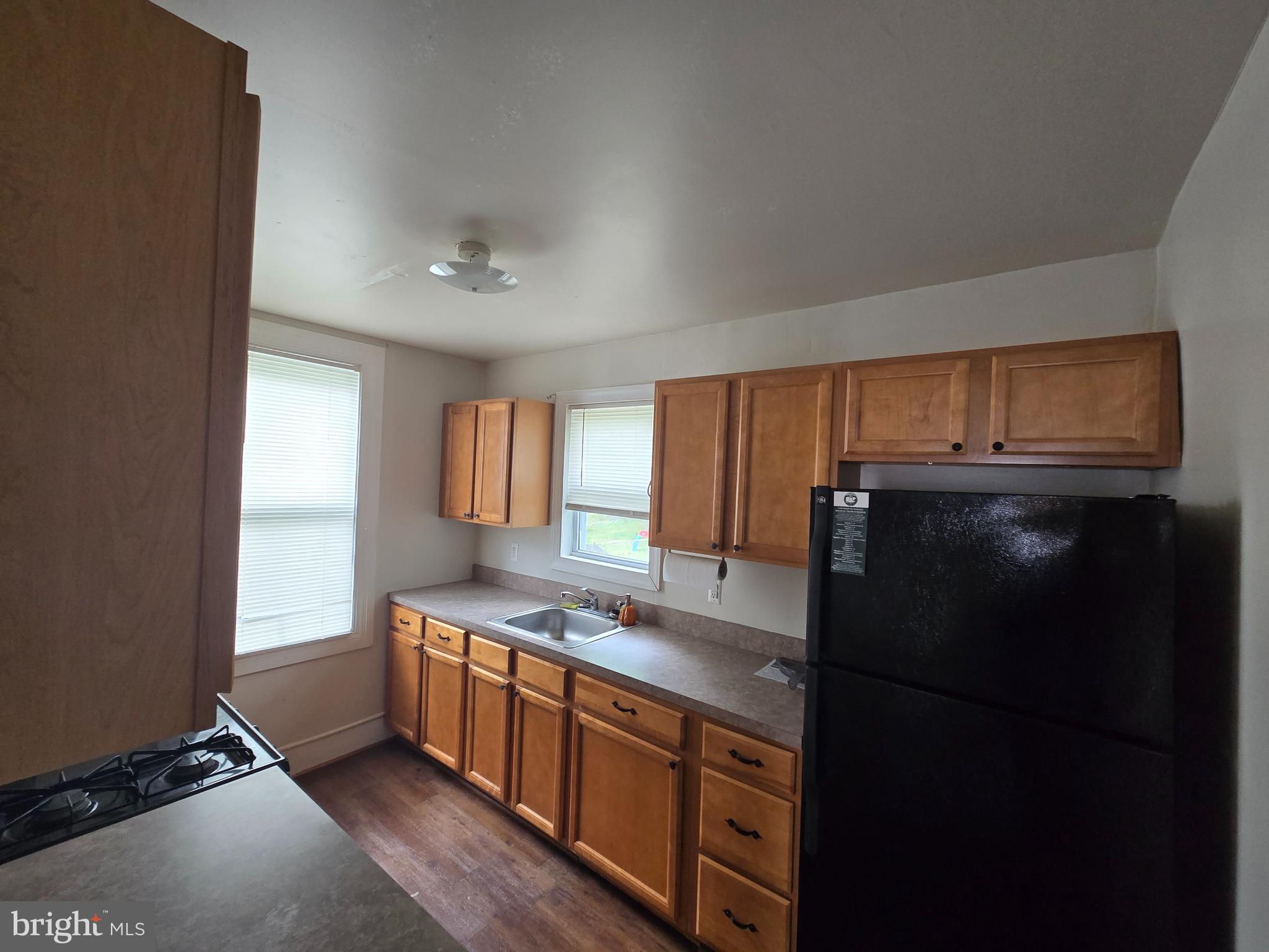 106 Main Street Mantua, NJ 08051 - Photo 7 of 23 a kitchen with stainless steel appliances granite countertop a refrigerator a sink dishwasher a stove and a dining table with wooden floor