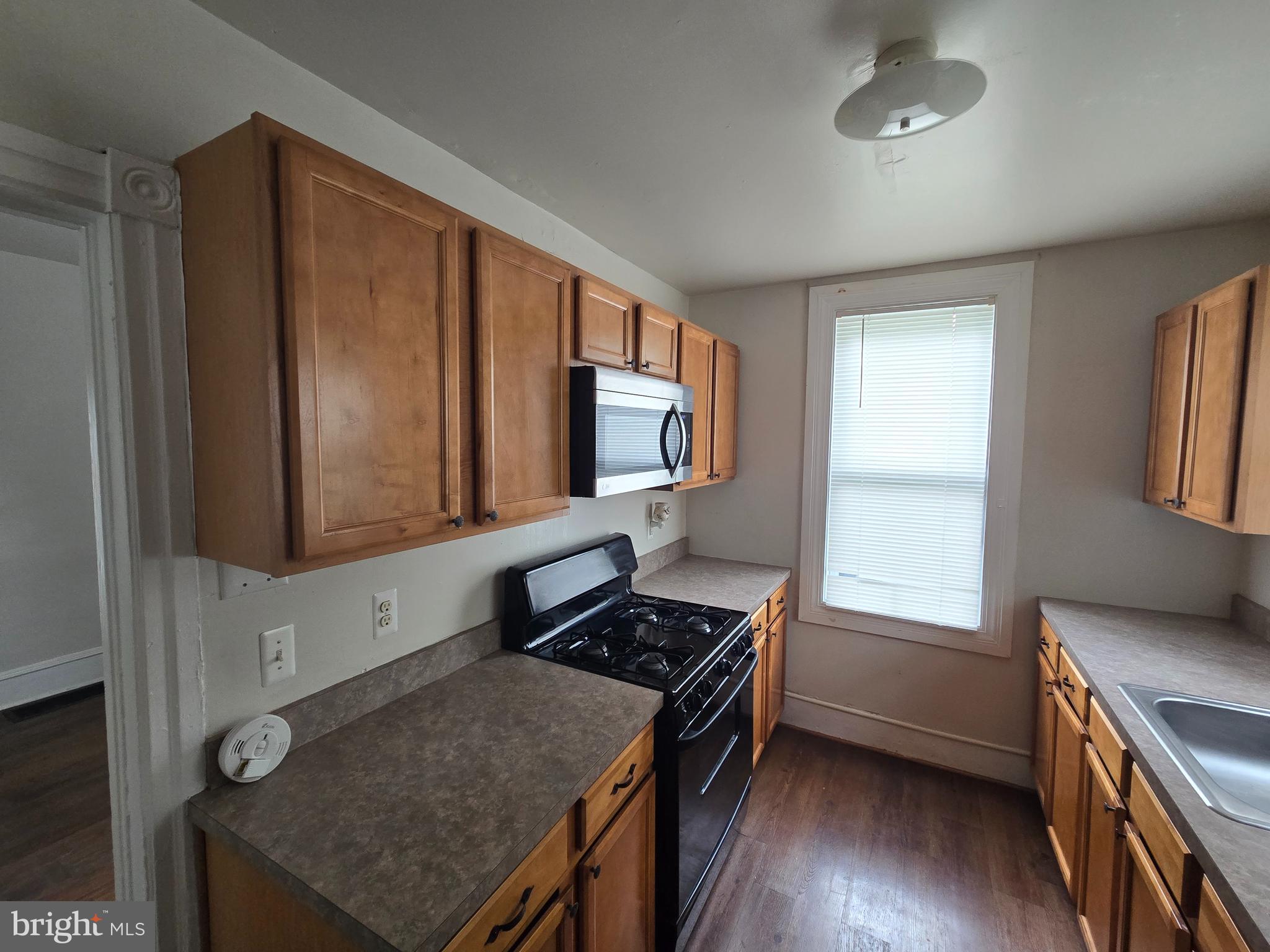 106 Main Street Mantua, NJ 08051 - Photo 8 of 23 a kitchen with stainless steel appliances granite countertop a stove a sink and a microwave