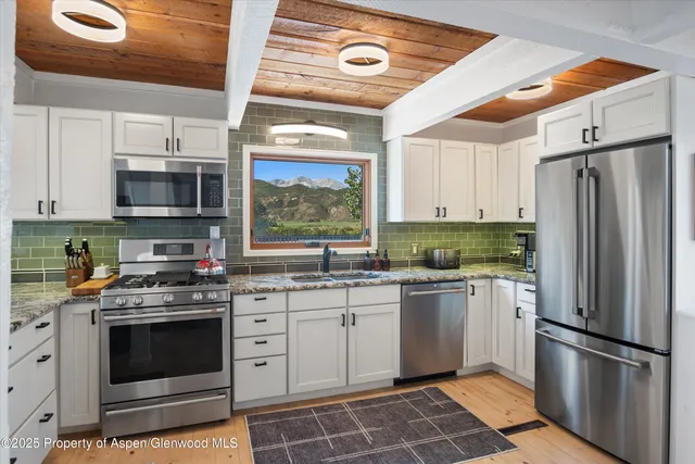 a kitchen with stainless steel appliances a stove a sink and a refrigerator