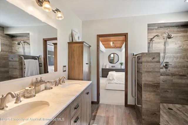 a en suite bathroom with a granite countertop sink mirror and shower