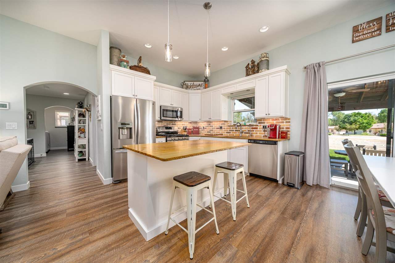 2330 E Road, Unit A & B Grand Junction, CO 81507 - Photo 29 of 35 a kitchen with stainless steel appliances kitchen island granite countertop wooden floors and white cabinets