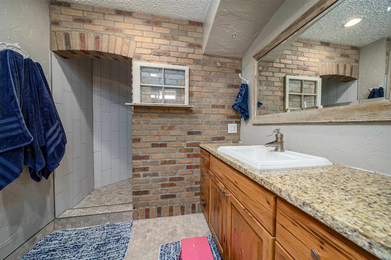 2330 E Road, Unit A & B Grand Junction, CO 81507 - Photo 7 of 35 a bathroom with a granite countertop sink a mirror and shower