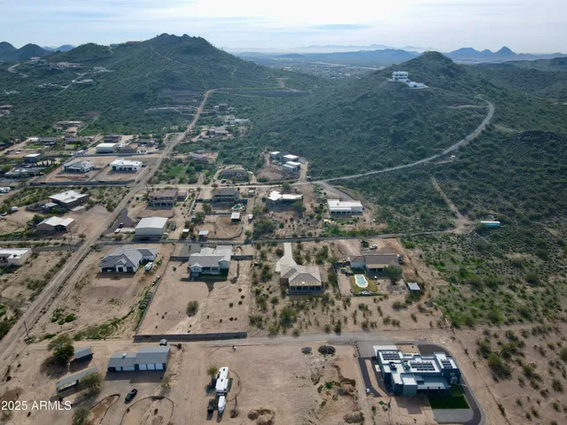 an aerial view of a house with a mountain