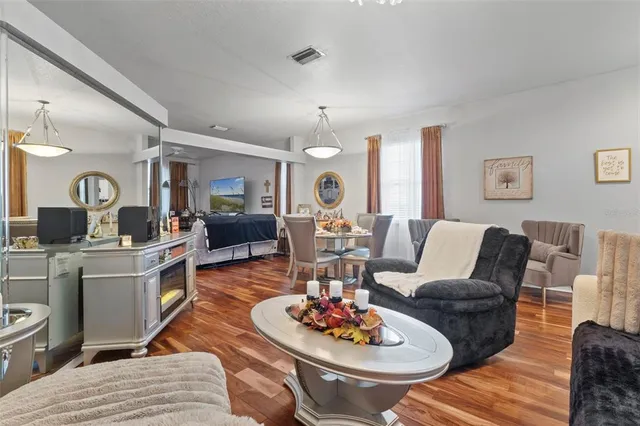 a living room with furniture kitchen view and a chandelier