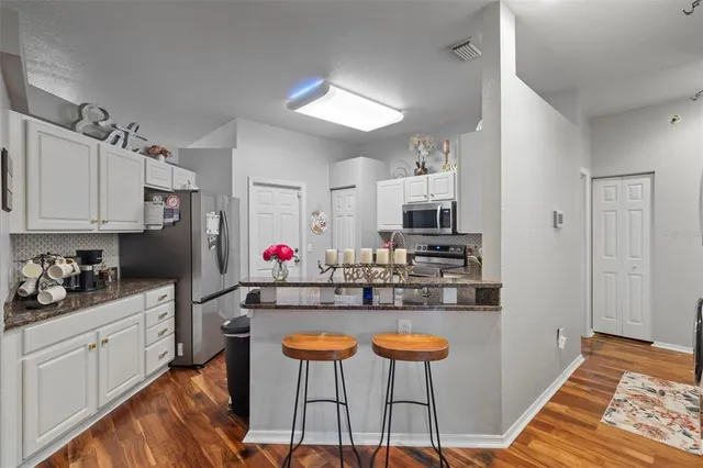 a kitchen with stainless steel appliances kitchen island granite countertop a sink and cabinets